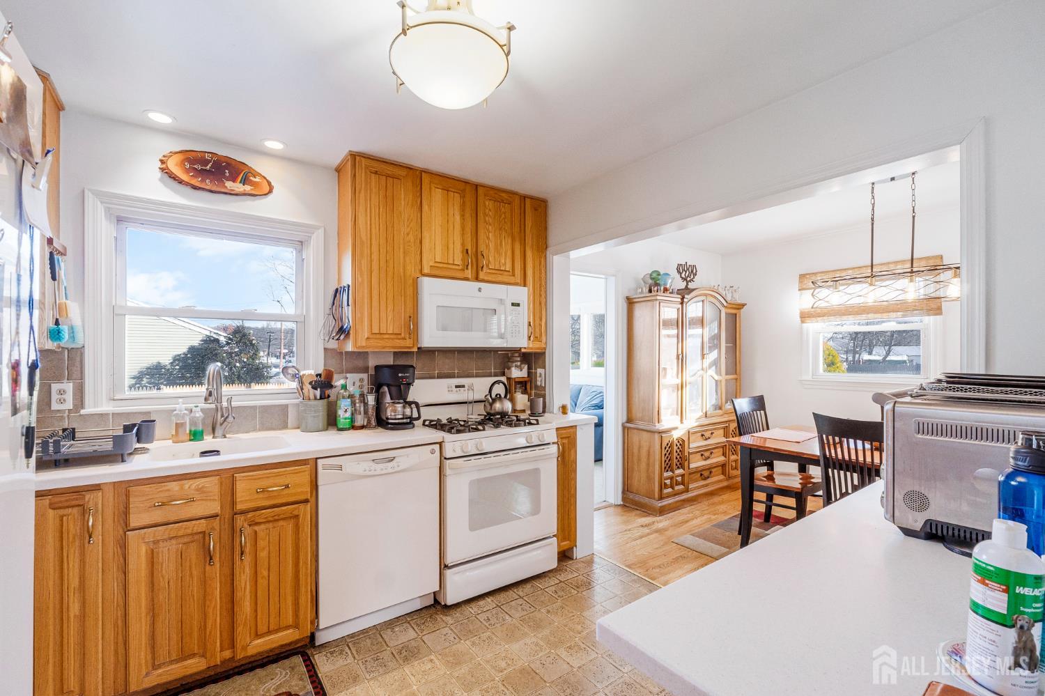 241 Cook Avenue Middlesex, NJ 08846 - Photo 11 of 33 a kitchen with stainless steel appliances a stove a sink dishwasher and a dining table with wooden floor