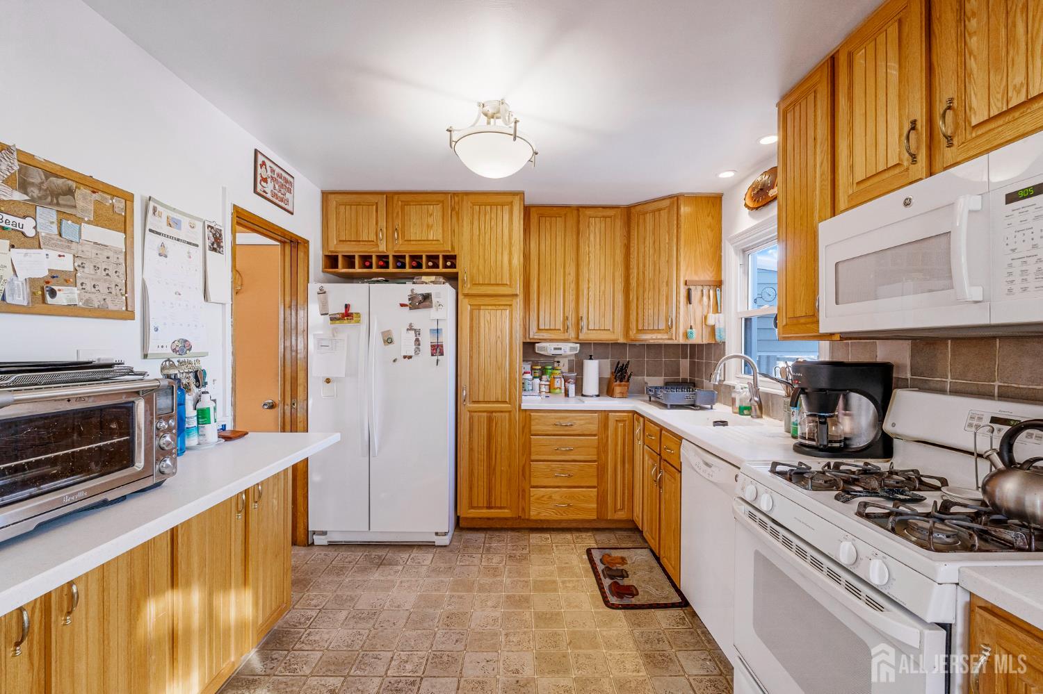 241 Cook Avenue Middlesex, NJ 08846 - Photo 9 of 33 a kitchen with stainless steel appliances granite countertop a stove top oven a refrigerator a sink and dishwasher with white cabinets