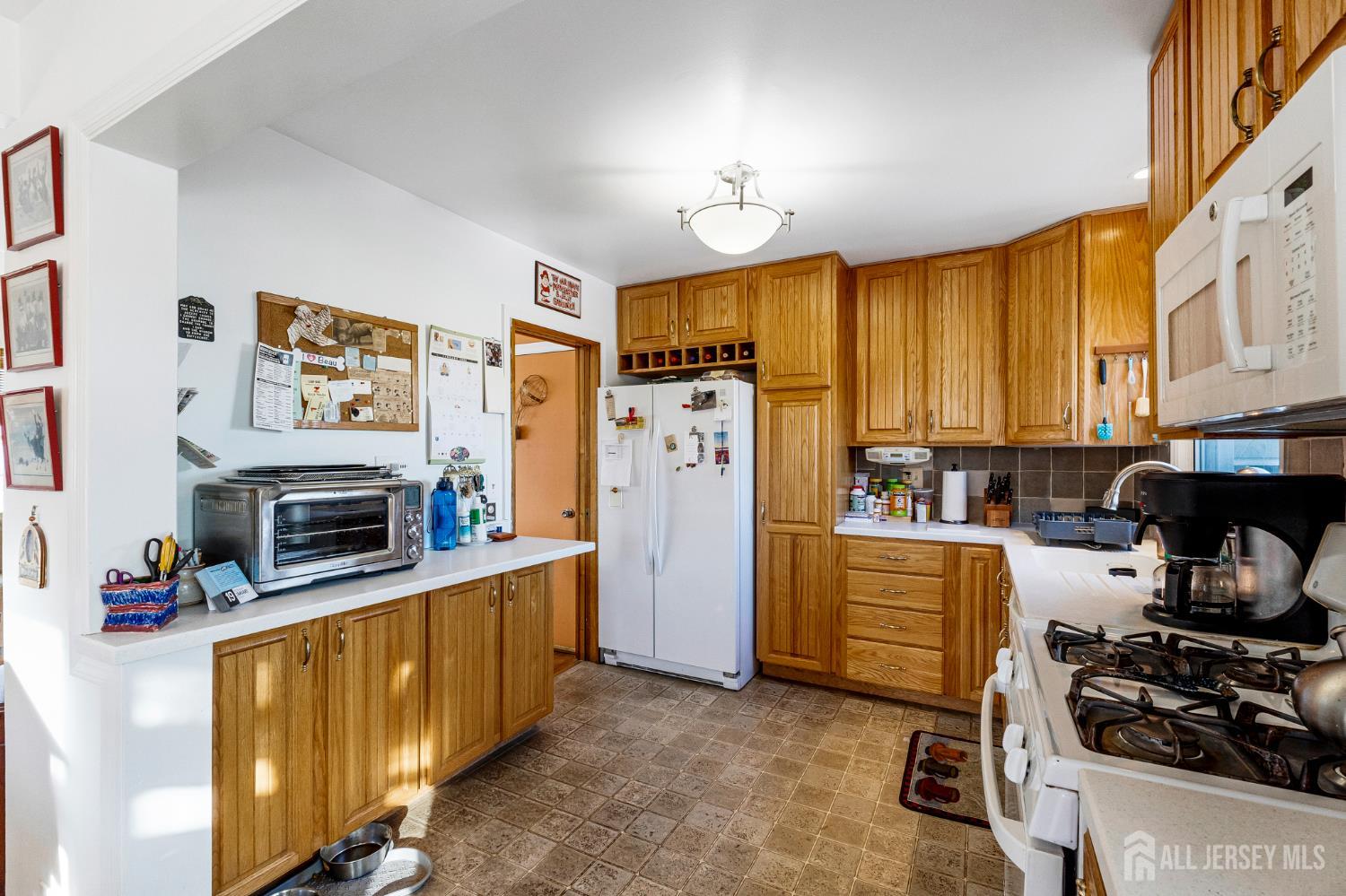 241 Cook Avenue Middlesex, NJ 08846 - Photo 10 of 33 a kitchen with stainless steel appliances a stove a refrigerator a sink dishwasher and a fireplace with wooden floor