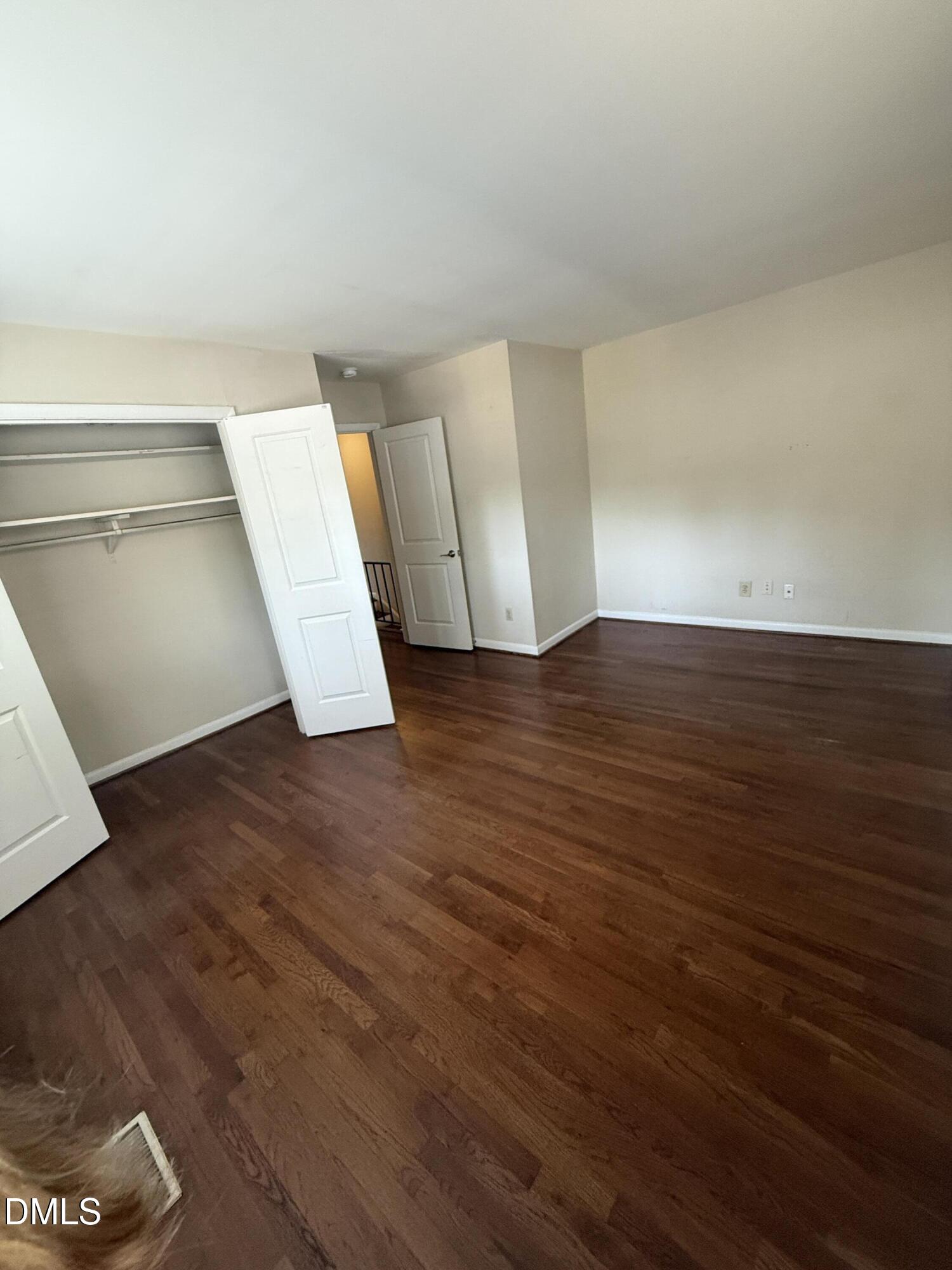 2616 Noble Road, Unit D Raleigh, NC 27608 - Photo 8 of 9 a view of an empty room with wooden floor and a window