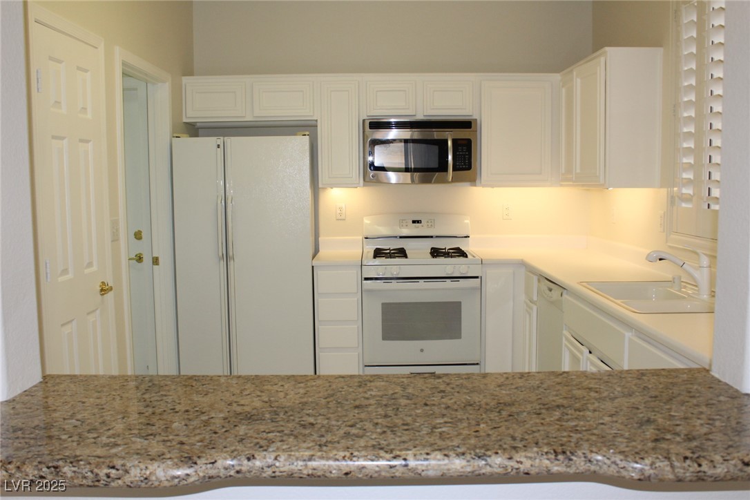 2013 Capestone Street Las Vegas, NV 89134 - Photo 9 of 40 Kitchen featuring white appliances, light stone co
