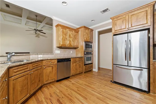 a kitchen with stainless steel appliances granite countertop a refrigerator a sink and a stove