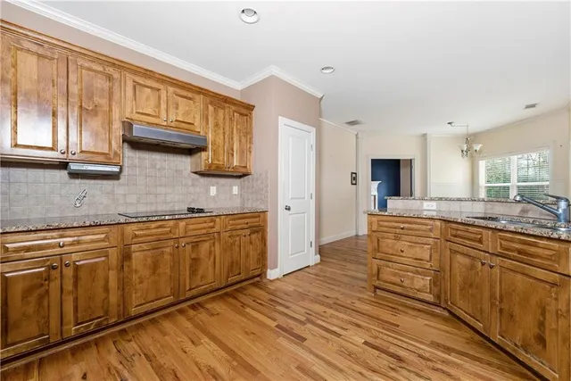 a large kitchen with stainless steel appliances granite countertop a stove and a sink