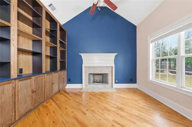a view of an empty room with a window and fireplace
