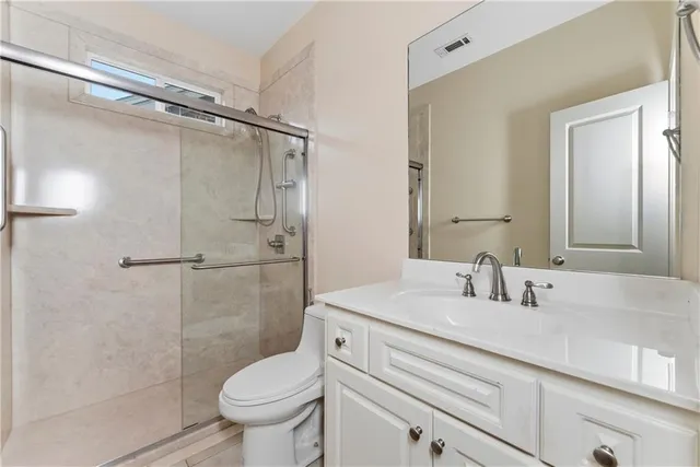 a bathroom with a granite countertop sink toilet and shower