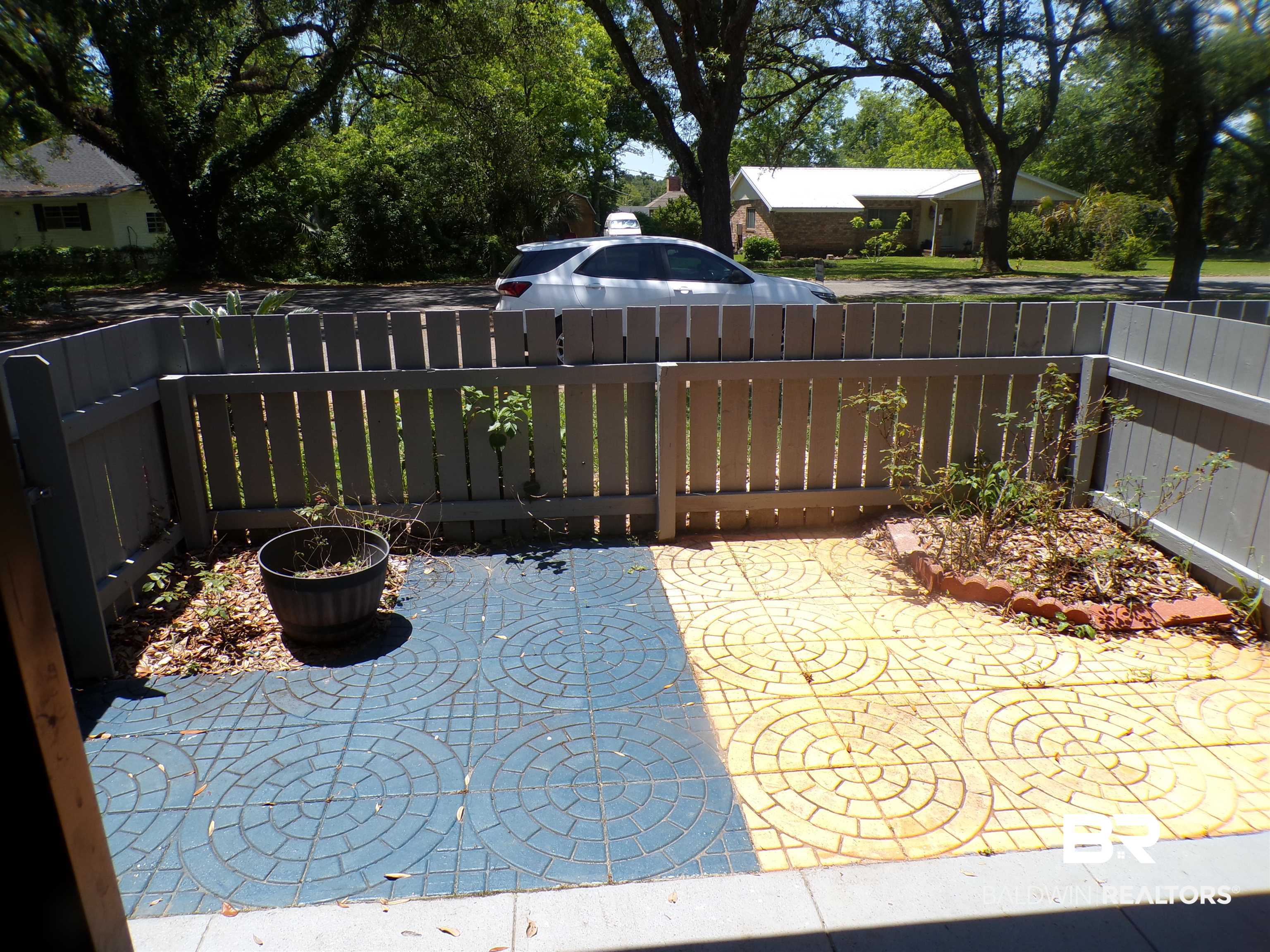 1152 North Alston Street, Unit 1152 Foley, AL 36535 - Photo 3 of 16 Private outdoor patio area featuring gray fencing and decorative paver flooring