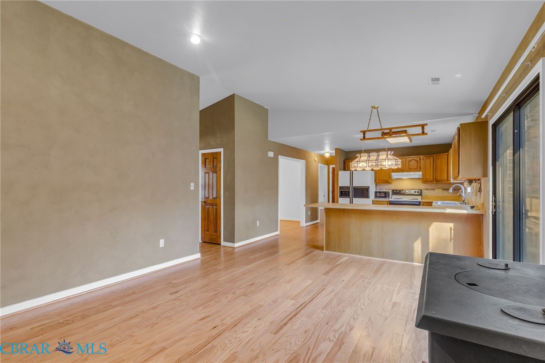 278 Regent Road Hartfield, VA 23071 - Photo 14 of 49 Kitchen with brown cabinets, light wood finished floors, range with electric stovetop, stainless steel fridge, and a peninsula