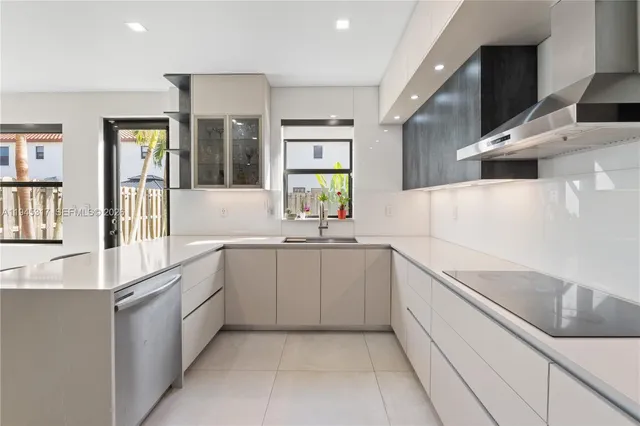 a large white kitchen with stainless steel appliances granite countertop a sink and dishwasher with a large window
