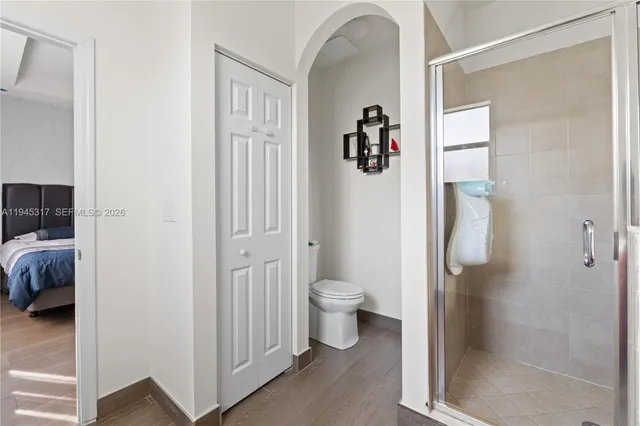 a bathroom with a granite countertop shower and a toilet