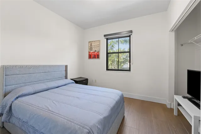 a bedroom with a bed and a tv on the dresser