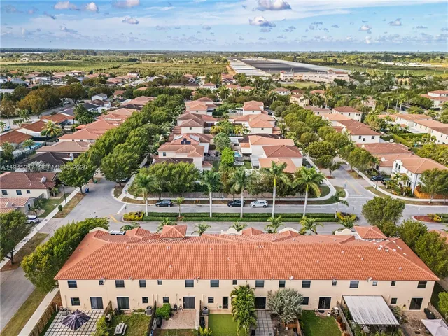 an aerial view of residential houses with outdoor space and swimming pool