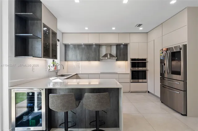 a kitchen with kitchen island stainless steel appliances a sink stove and refrigerator