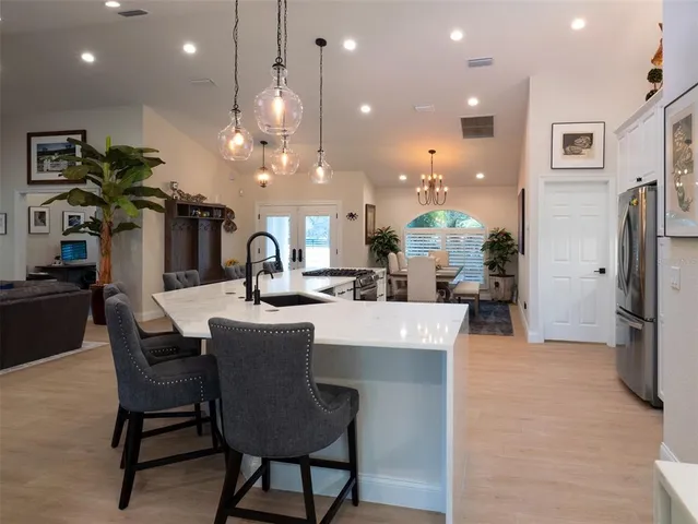a living room with furniture kitchen view and a chandelier