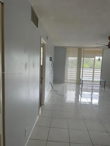 an empty room with wooden floor and entrance