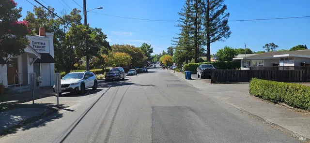 an empty room with wooden floor a fireplace and windows