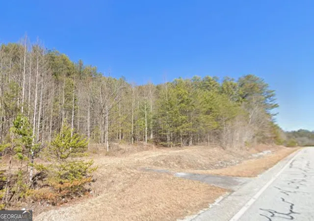 a view of a yard with wooden fence