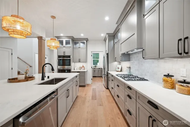 a kitchen with stainless steel appliances a sink stove top oven and cabinets