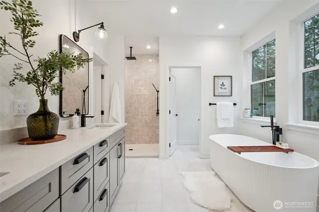 a bathroom with double vanity sinks a large mirror and a shower