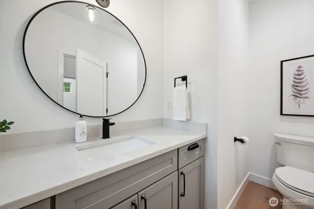 a bathroom with a toilet a sink and mirror