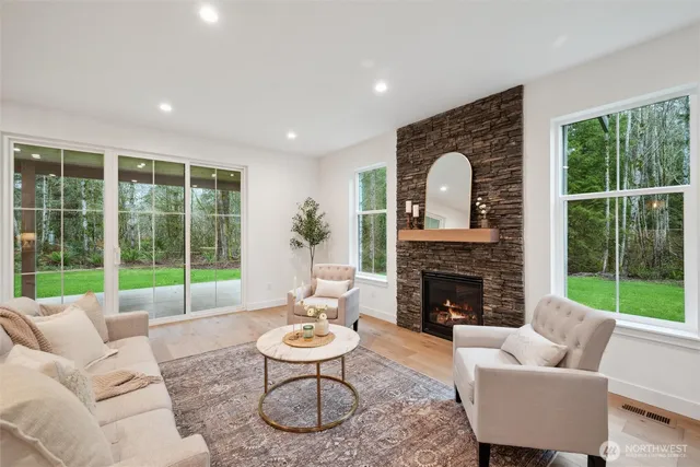 a living room with furniture a fireplace and a floor to ceiling window