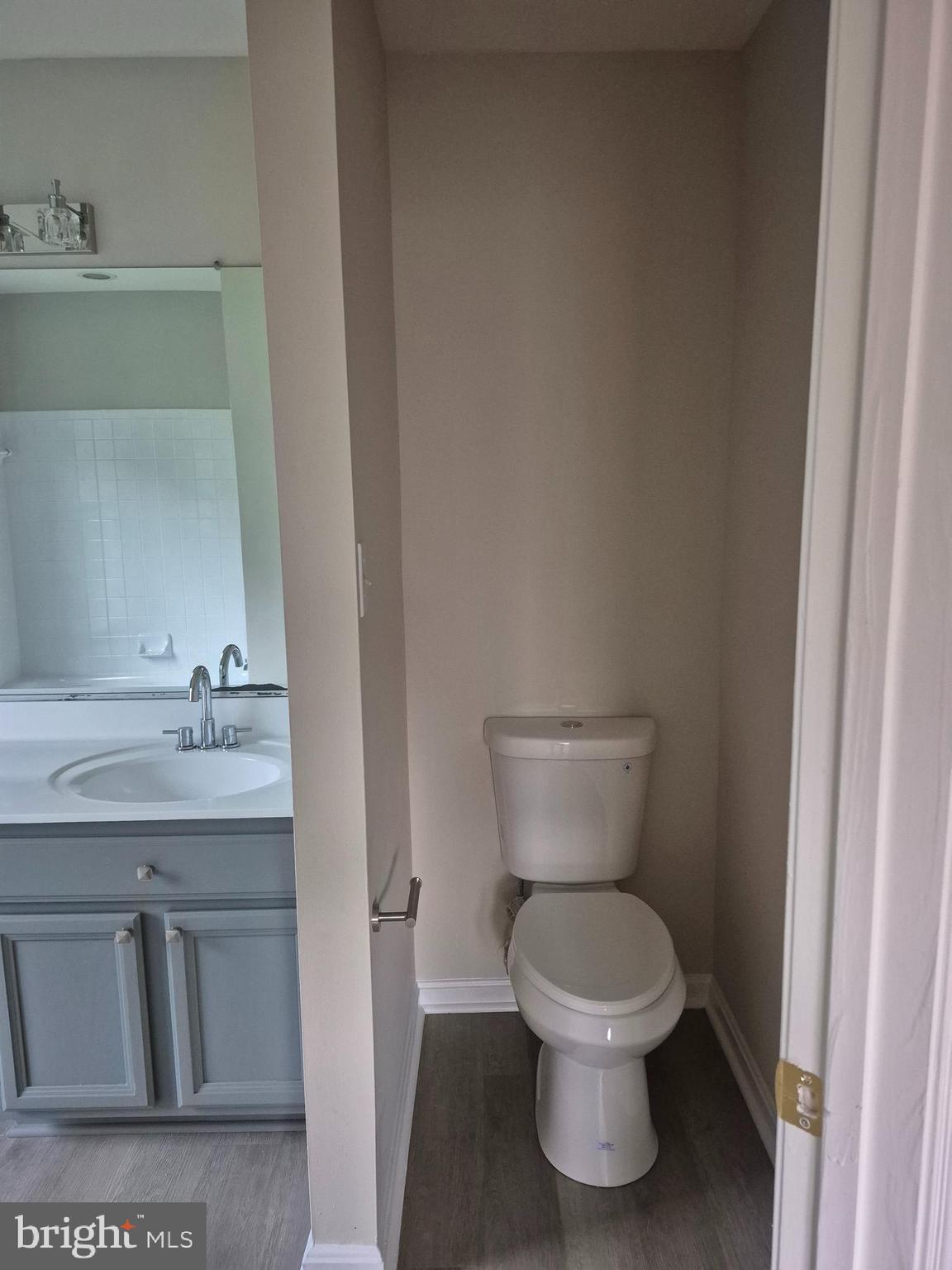 7006 Chain Fern Court Clinton, MD 20735 - Photo 16 of 23 a bathroom with a toilet sink and mirror