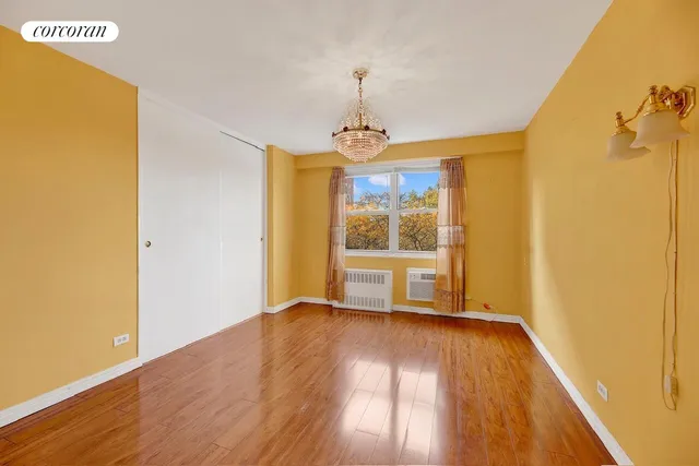 a view of a room with wooden floor a ceiling fan and windows