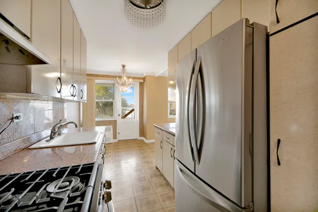 a kitchen with stainless steel appliances granite countertop a refrigerator and a sink