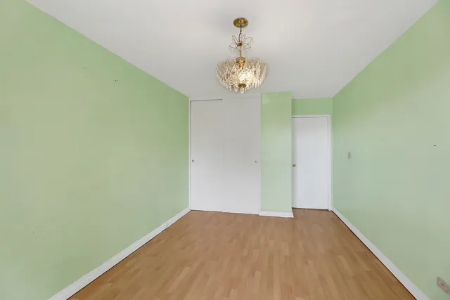 a view of a room with wooden floor and a ceiling fan