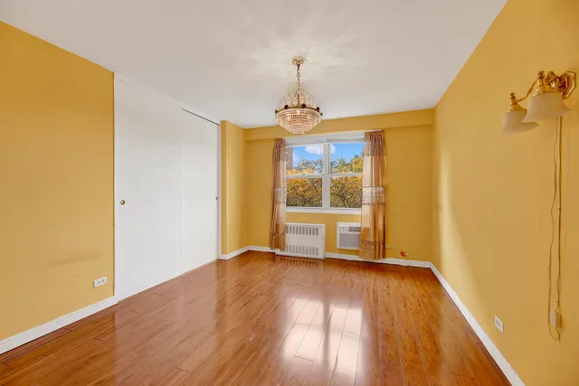 a view of a room with wooden floor a ceiling fan and windows