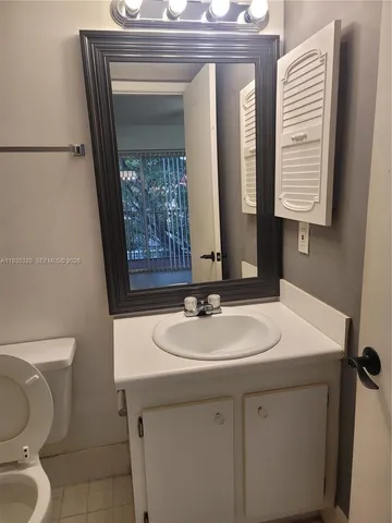 a bathroom with a granite countertop sink and a mirror