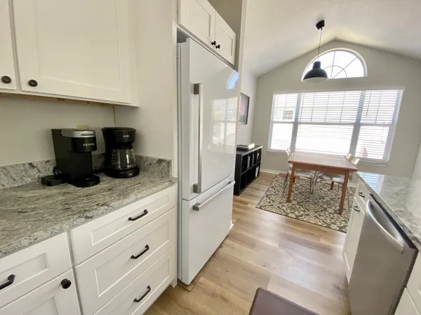 a kitchen with granite countertop a stove a sink and a refrigerator