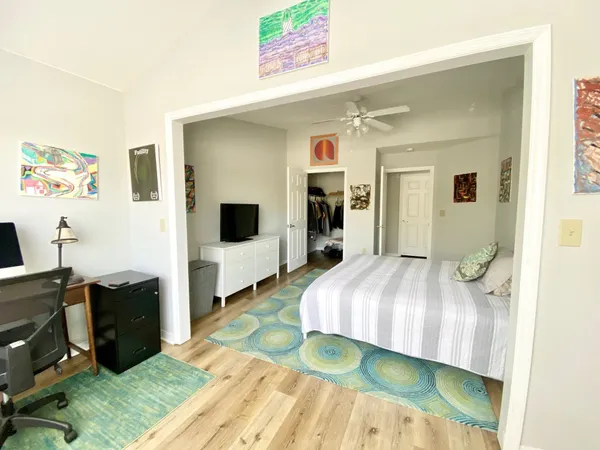 a bedroom with a bed and a flat tv screen on dresser