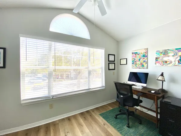 a view of a workspace with furniture and a window