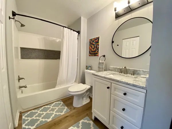 a bathroom with a granite countertop sink toilet and shower