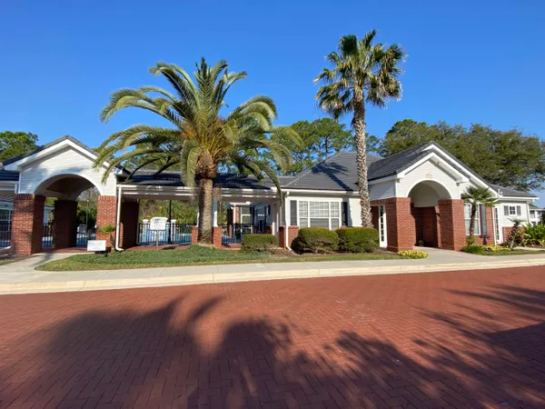a view of a white house with a big yard and potted plants