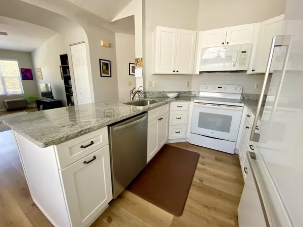 a kitchen with stainless steel appliances granite countertop a sink stove and cabinets