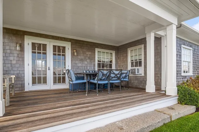 a view of a patio with table and chairs and floor to ceiling window