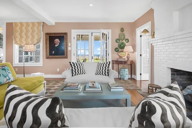 a living room with furniture fireplace and a large window