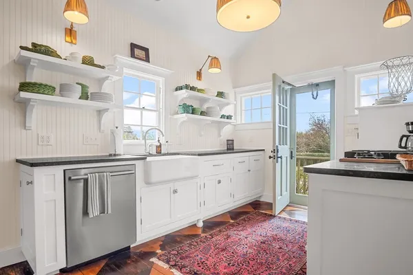 a kitchen with cabinets and wooden floor