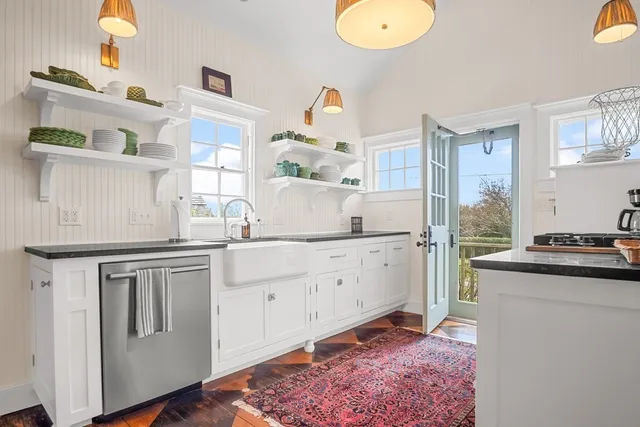 a kitchen with cabinets and wooden floor