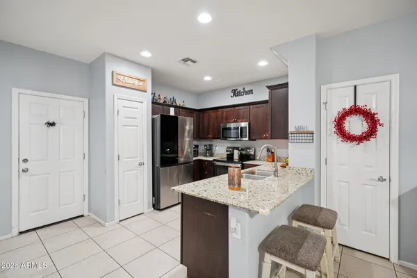 a kitchen with stainless steel appliances granite countertop a refrigerator a sink a stove a microwave and island