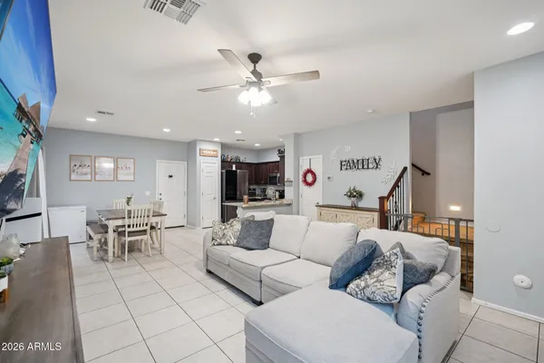 a large white kitchen with stainless steel appliances granite countertop a stove a sink a dining table and chairs with wooden floor