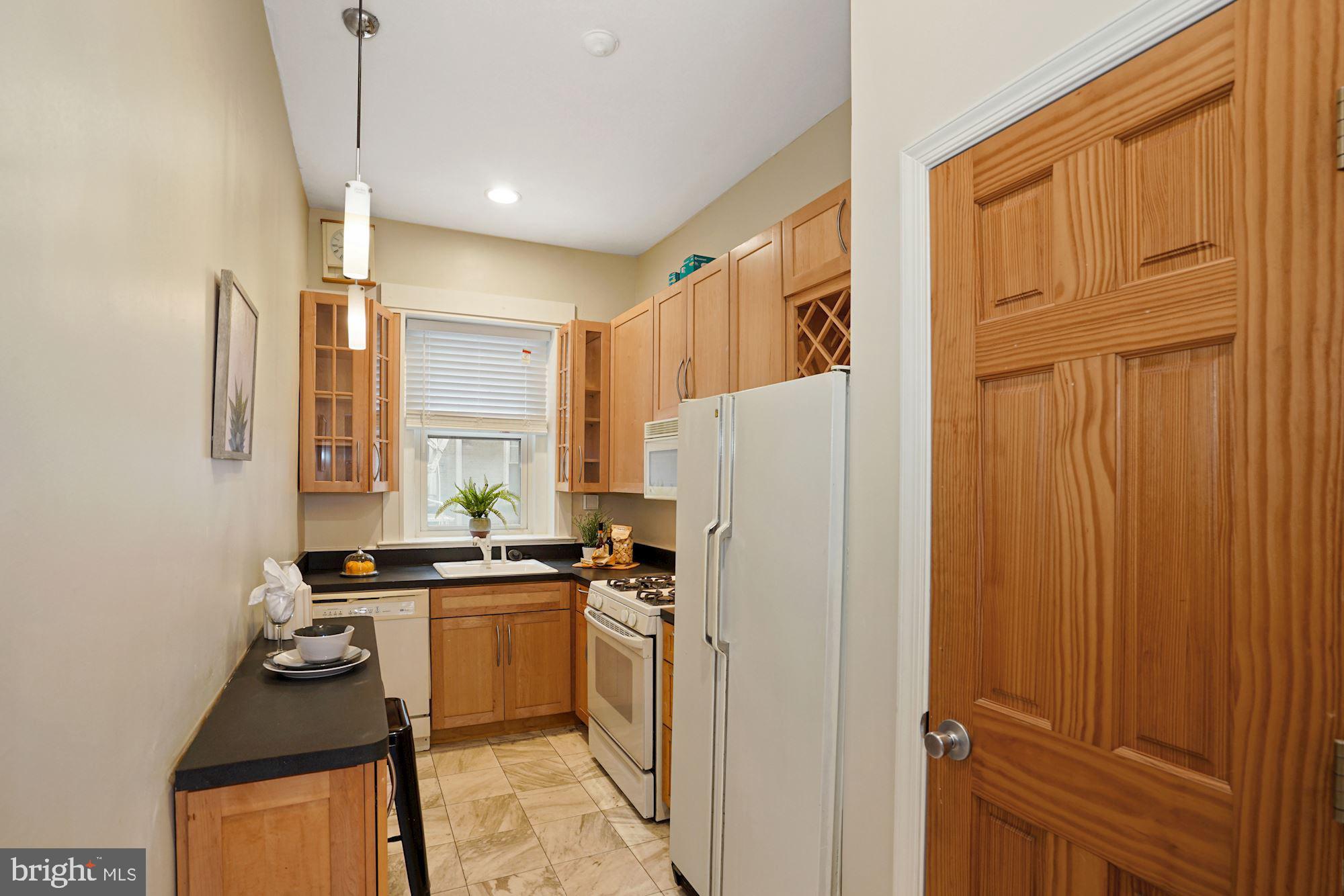1322 15th Street Northwest, Unit 3 Washington, DC 20005 - Photo 12 of 16 a kitchen with a refrigerator a sink and cabinets