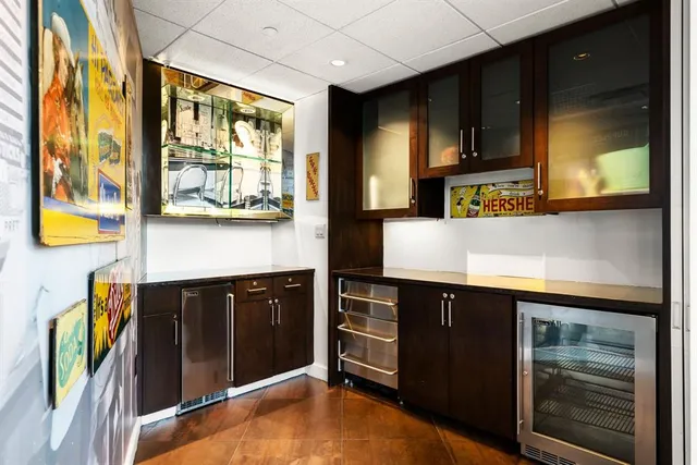 a dining hall with stainless steel appliances kitchen island granite countertop a table chairs in it and a large window