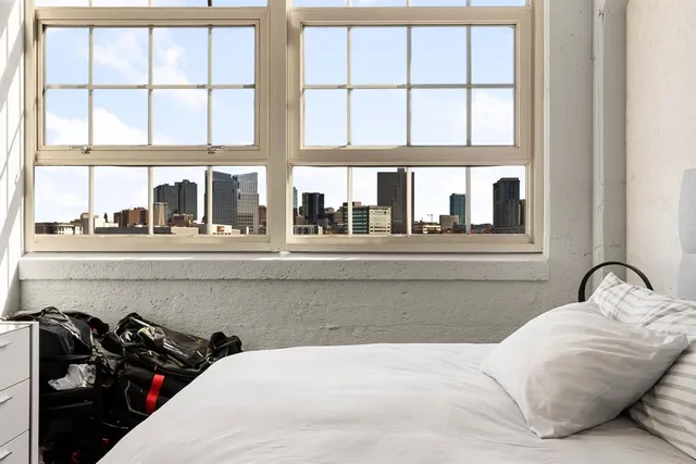 a bedroom with a bed and a large window