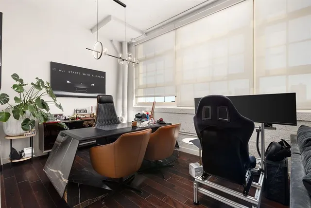 a living room with furniture a flat screen tv and a window