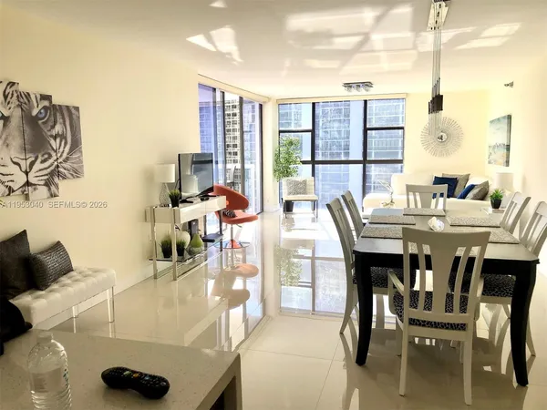 a dining room with furniture and a floor to ceiling window
