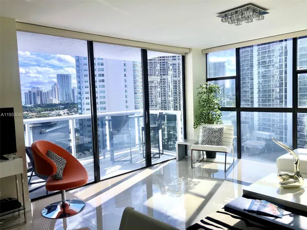 a living room with furniture and a floor to ceiling window
