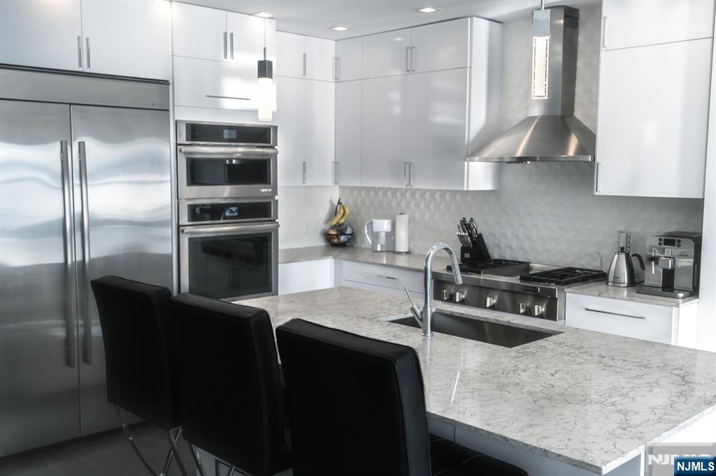 314 The Promenade Edgewater, NJ 07020 - Photo 6 of 37 a kitchen with stainless steel appliances granite countertop a sink a stove and a refrigerator