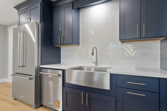 a kitchen with stainless steel appliances granite countertop a refrigerator and a sink